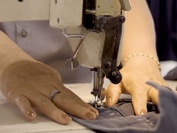 hands fixing uniform with sewing machine